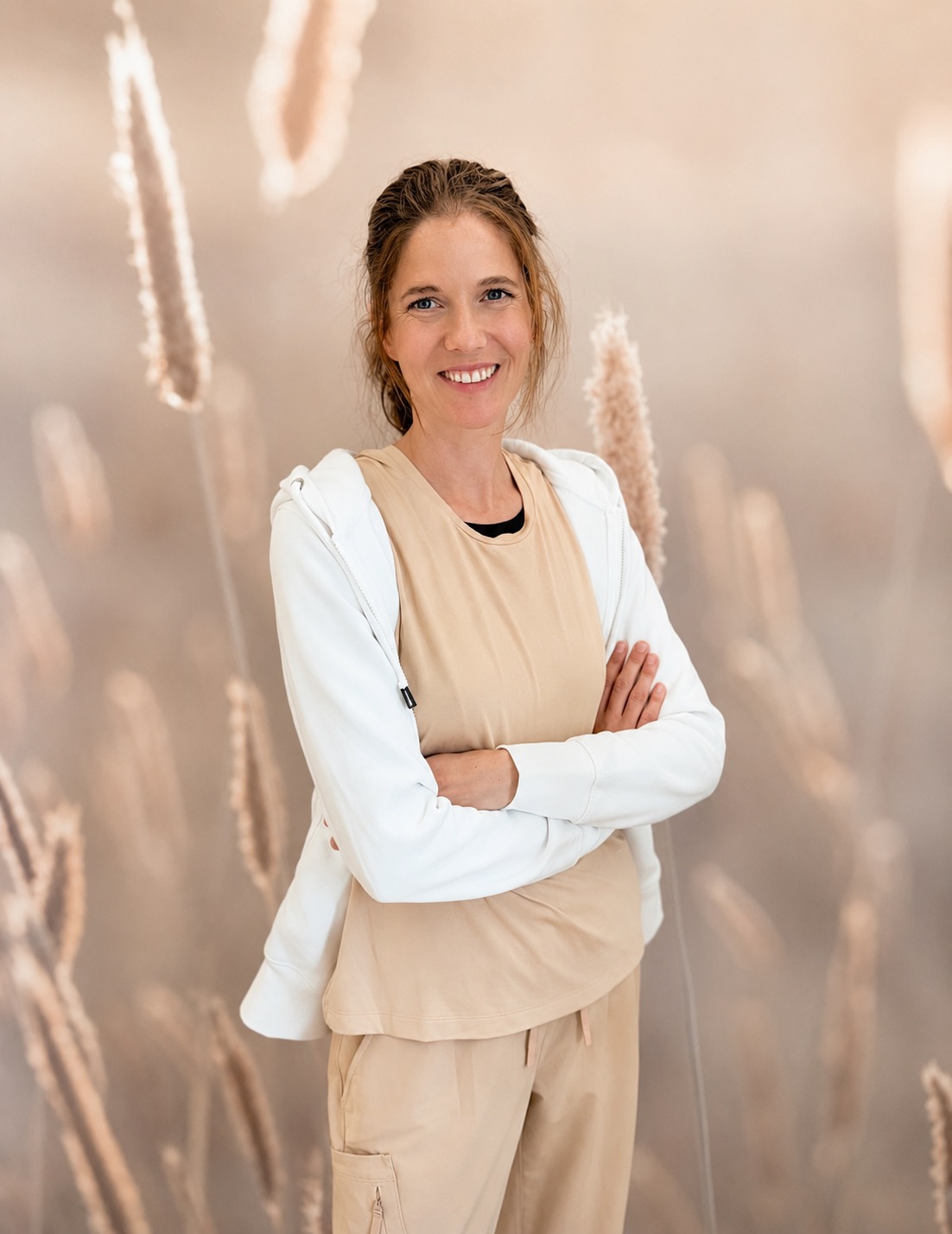 eine Frau mit dunklem Pferdeschwanz lächelt Sie an 
